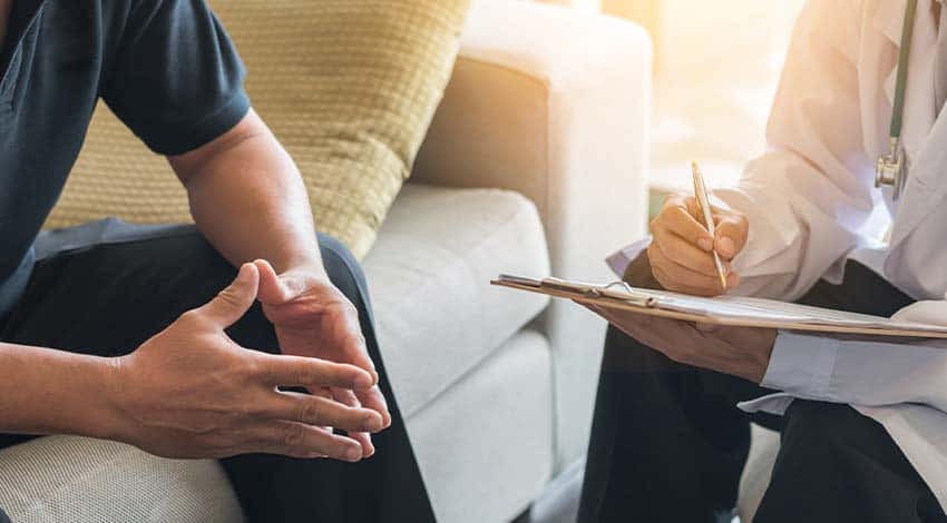 patient sitting with doctor during mens rehab