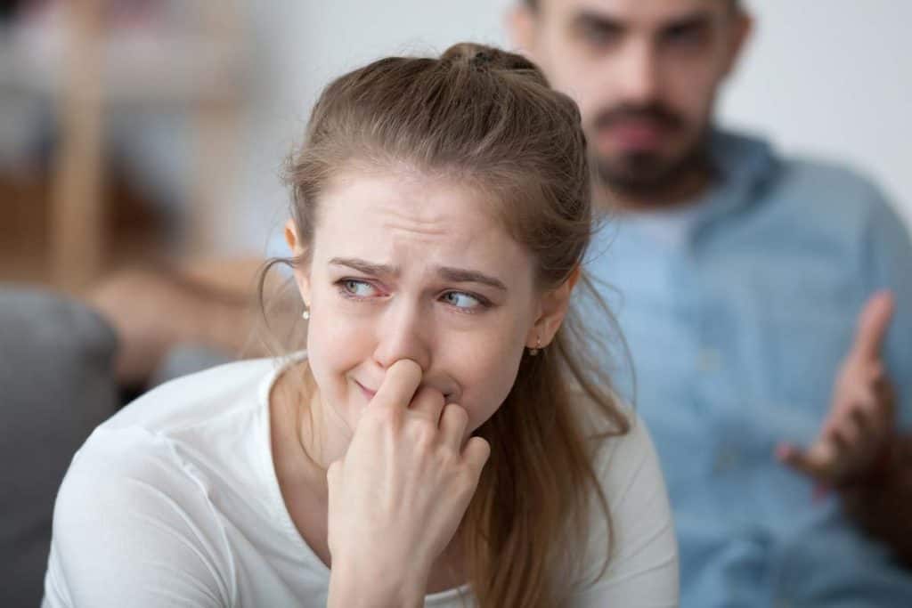 distraught woman in tears sitting with her alcoholic husband