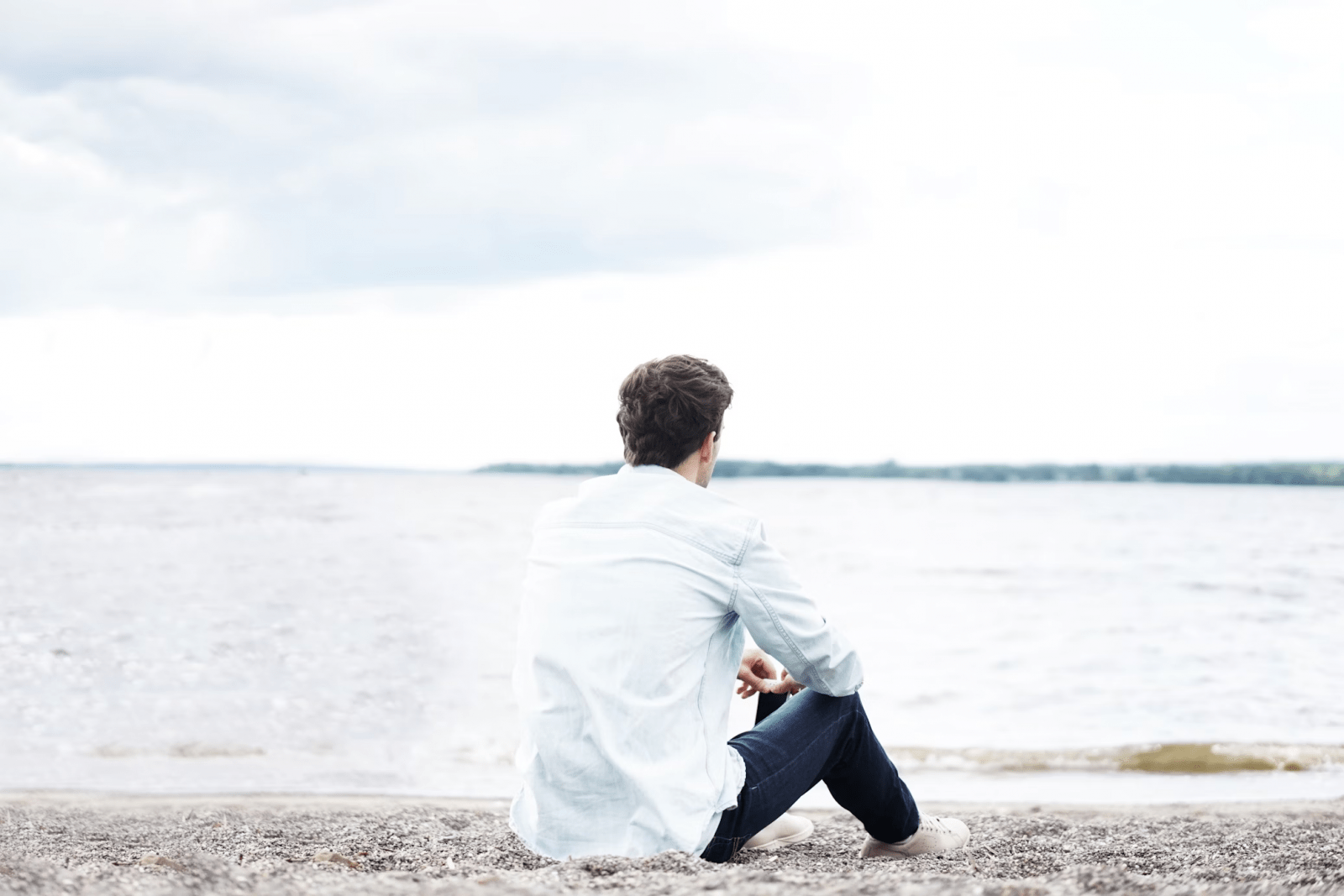 person sitting on beach and thinking about recovery